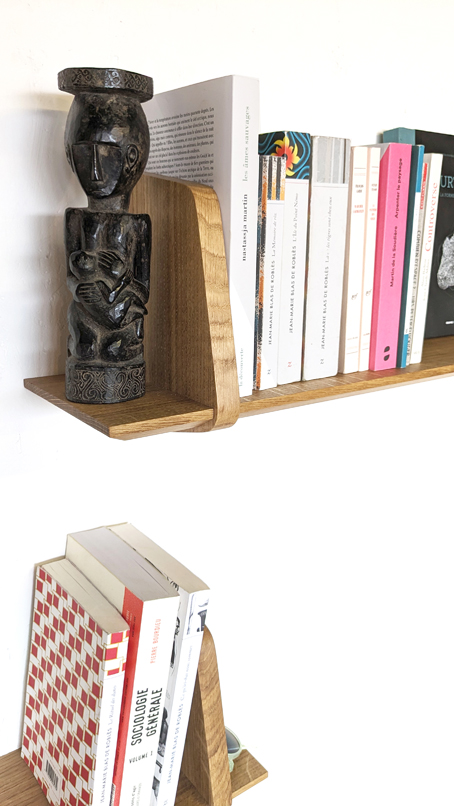 étagère sur mesure en chêne massif sur lesquelles sont rangés des livres et une statue en ébène noire du Gabon. Création de l'atelier Jules B à Nantes.